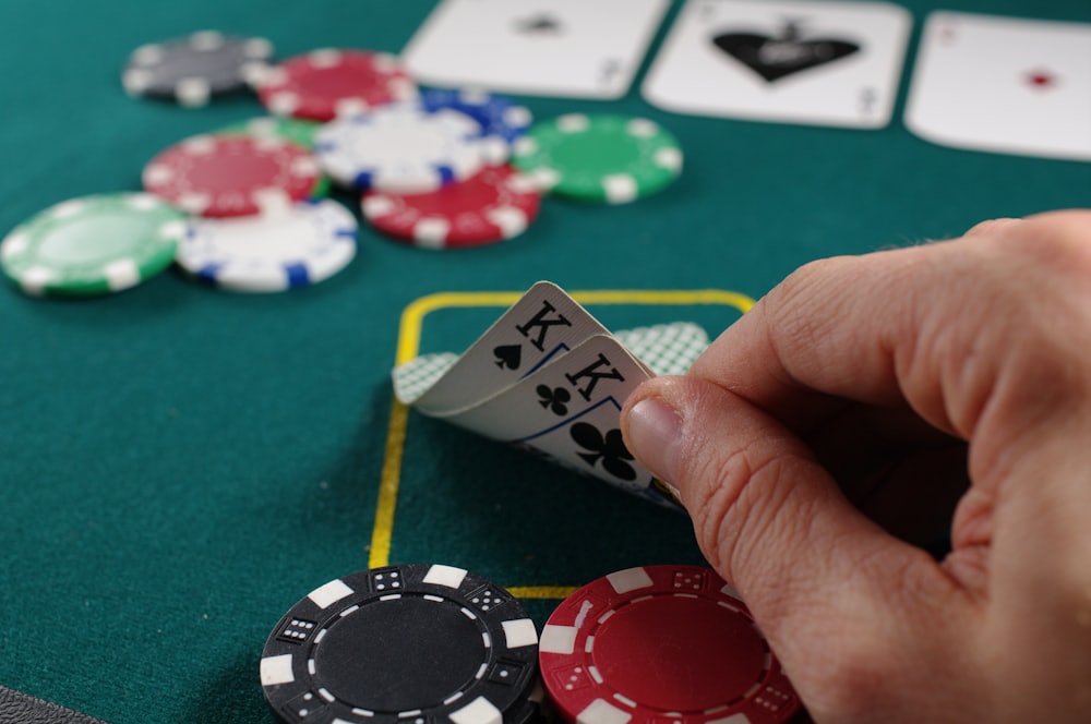 Chips dan kartu poker di atas meja felt hijau